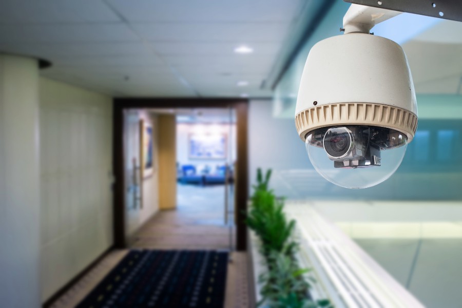 Wall-mounted security camera in a hallway.