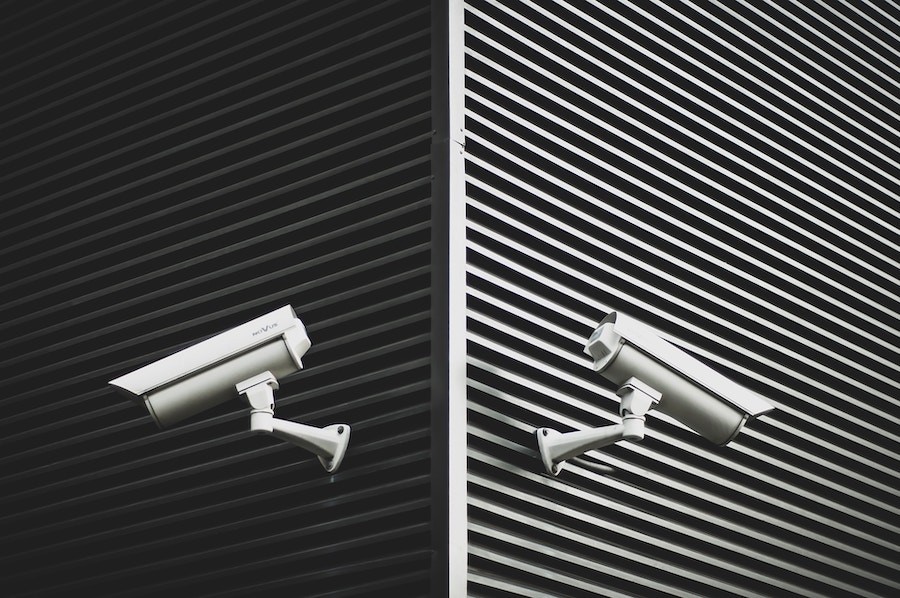 A pair of commercial security cameras on two outside walls of a building in Kansas City.