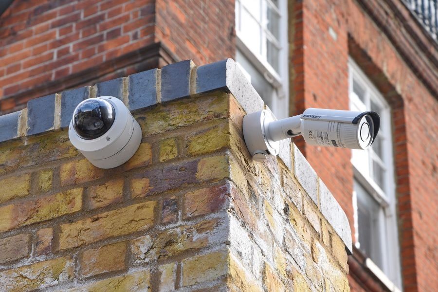 Two security cameras installed on the side of a building.